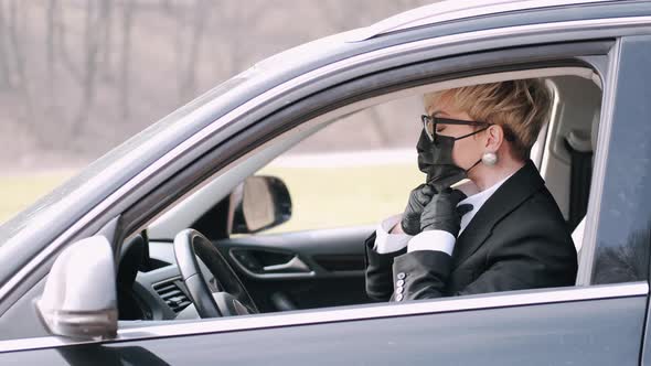 The Businesswoman in Black Style Wearing Protective Mask Is Driving a Car