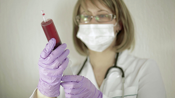 Doctor is Very Large Syringe Full of Blood