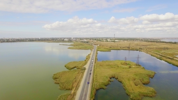 Two Way Road Between Lakes With Moving Cars 