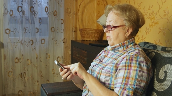 Old Woman Using Smartphone At Home
