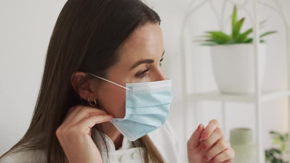 Portrait of caucasian female beautician putting face mask on