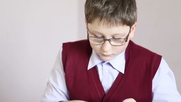 Boy With Glasses Playing The Tablet At School