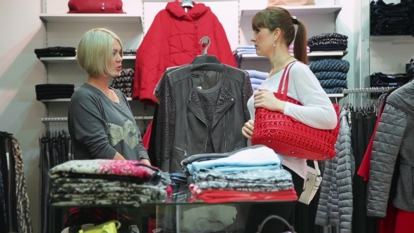 Shopping. Girlfriends Choosing Bags And Clothes