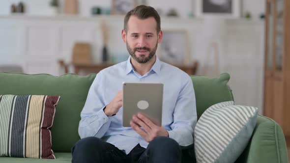 Young Man Celebrating Win on Tablet Success