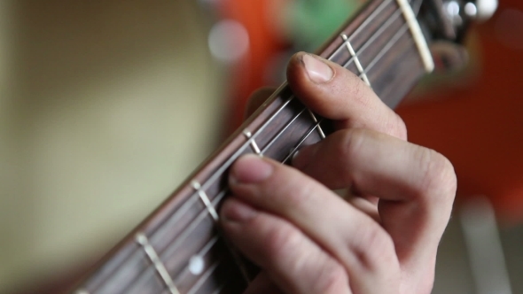 Man Plays Guitar, His Fingers On The Fretboard 