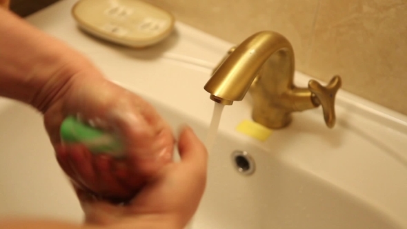 Man Washes His Hands Under The Tap
