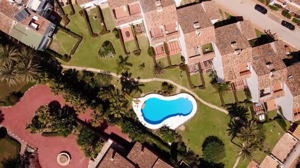 Swimming Pool Of Resort In Estepona Town At Summer In Costa del Sol, Andalusia, Spain. - aerial orbi