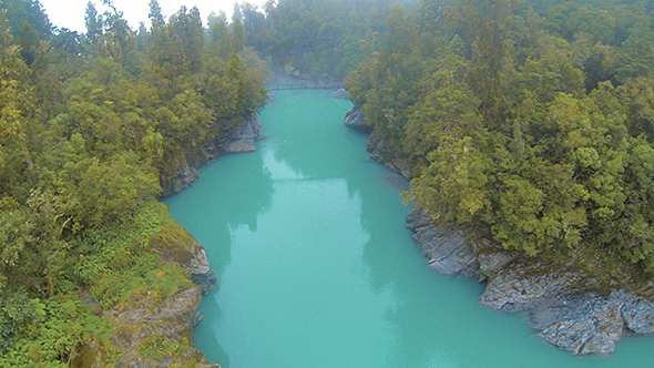 Turquoise Creamy River Flowing Through a Gorge Flying In