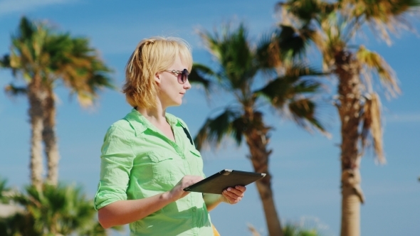 A Tourist Looks For Way From The Map On The Tablet