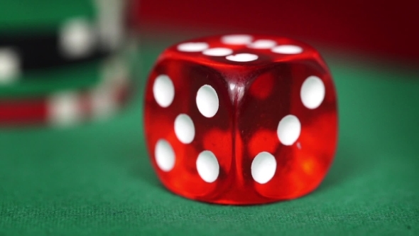 Red Dice Rotation And Casino Chips On Green Felt