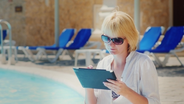 Woman In Sunglasses Enjoys The Tablet Pool