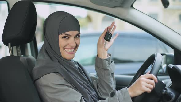 Smiling Lady in Hijab Showing Car Keys to Camera Buying New Auto Driving License