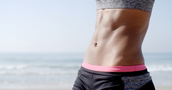 Young Fit Woman's Belly Outdoors In Summer