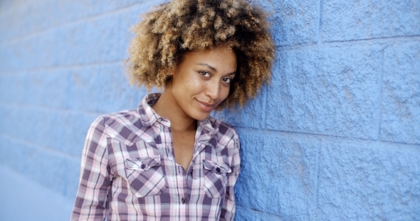 Black Woman Leaning Against Wall