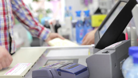  Man Standing Behind the Cash Register at the Store