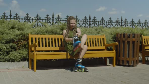 Female Roller Putting on Roller Blades on Bench