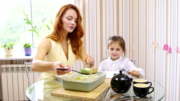 Young Mother Puts Freshly Baked Quiche To Her Little Daughter, Family Dinner