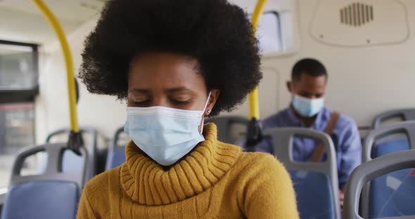 African american businesswoman with face mask sitting in bus