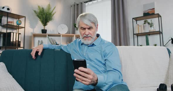 Retired Man Talking During Video Call on Smartphone