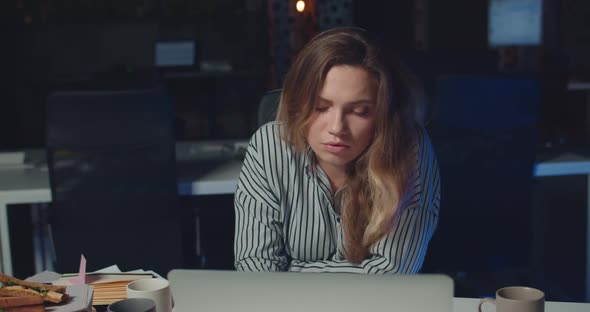 Portrait of Tired Beautiful Woman Looking To Camera While Staying Late in Night Office. Beautiful