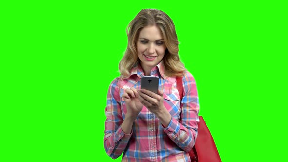 Smiling Girl Using Phone on Green Screen.