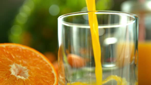 Super Slow Motion Shot of Fresh Orange Juice Being Poured in a Glass at 1000Fps