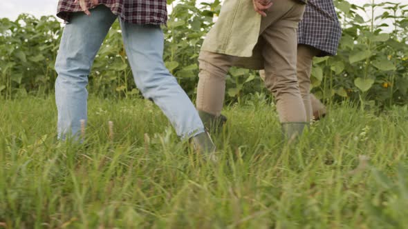 Unrecognizable Farmers Walking In Field