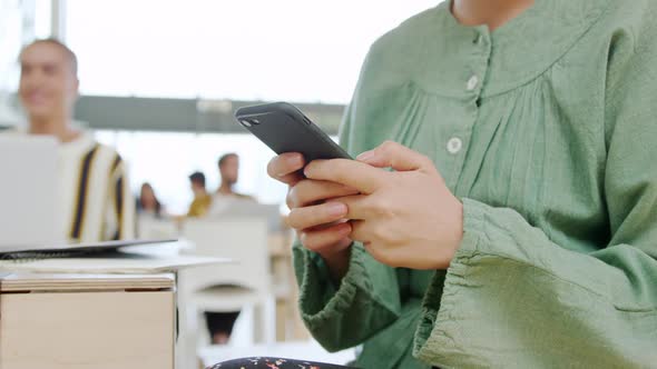 Woman using smartphone working in a modern office