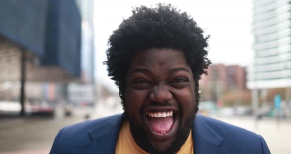 Happy african curvy man laughing on camera outdoor