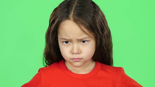 Close-up Girl Showing Emotion Punishment on Green Background. Slow Motion