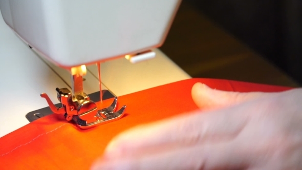 Woman Sews On The Sewing Machine