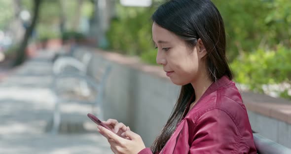 Woman use of mobile phone in city park