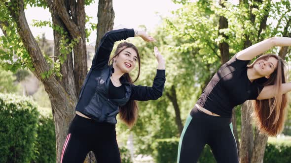 Two Beautiful Athletic Girls Are Doing Gymnastics Outdoors