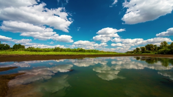  With Running Clouds With Reflection In Water And Deep Blue Sky