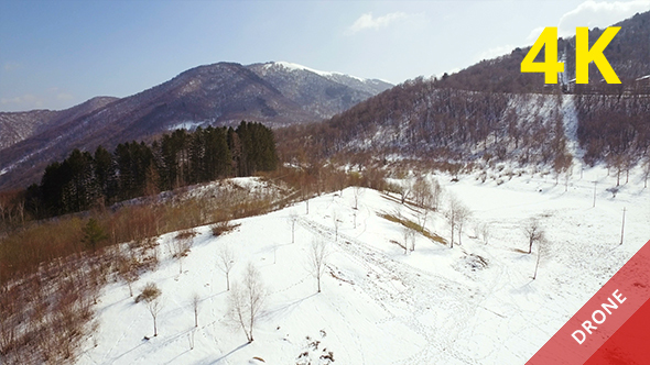 Flying over Snowy Mountains in a Sunny Day