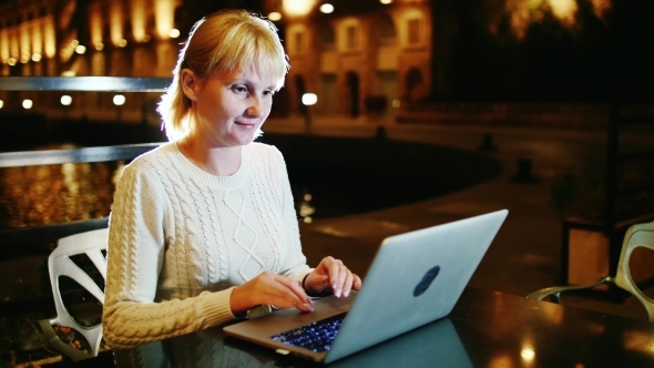 Young Woman Working With a Laptop In a Cafe Outdoor