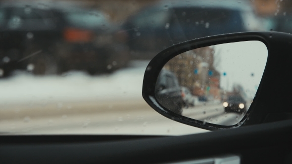 Cars Driving On a Snowy Road. The Reflection In The Rearview Mirror alt