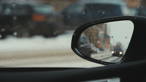 Cars Driving On a Snowy Road. The Reflection In The Rearview Mirror