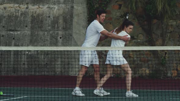 Woman and man playing tennis on a sunny day