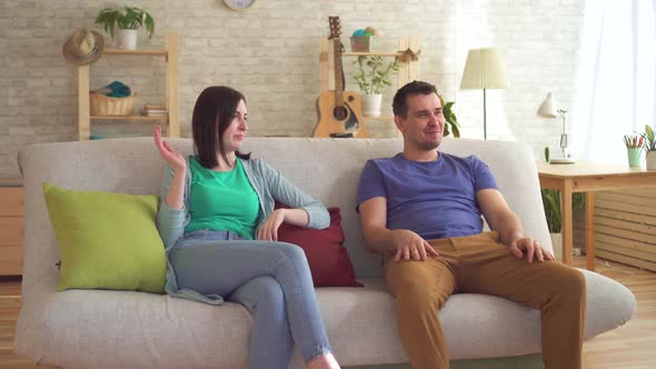 Young Man Farted Sitting on the Couch Next To a Young Woman Who Wore a Respirator From the Smell