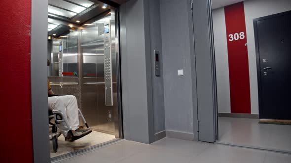 Man in a Wheelchair Rolling Out of an Elevator