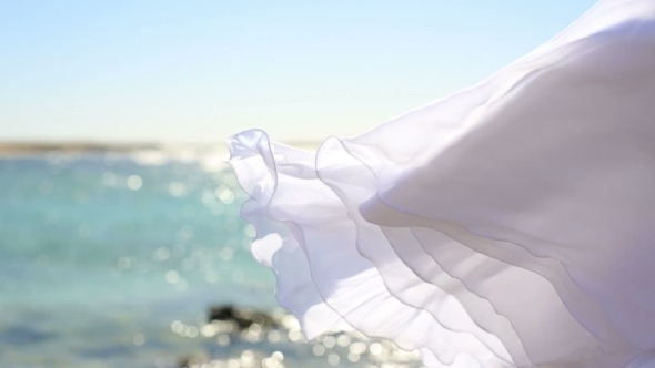 White Wedding Dress Fluttering In The Wind. Sea Background