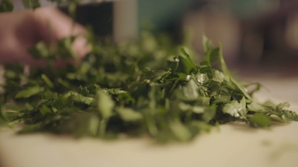 Cutting Fresh Organic Parsley With Knife On Wooden Cutting Board.