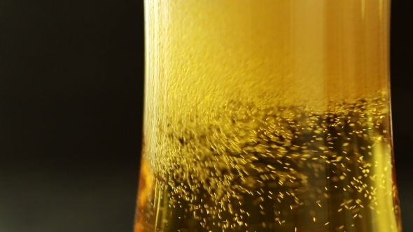 Pour The Flavored Beer Into a Glass On Wooden Table