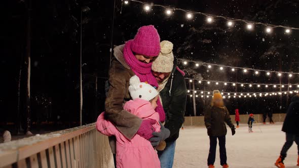 Happy Family at Outdoor Skating Rink in Winter