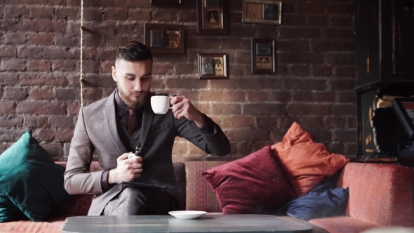 Man Using an Advanced Personal E-cigarette and Drink Coffee