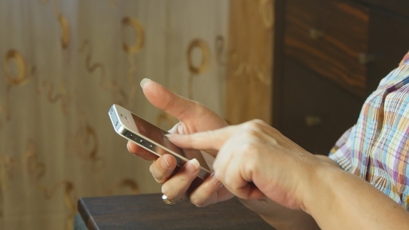 Hands Of The Old Woman And Smartphone