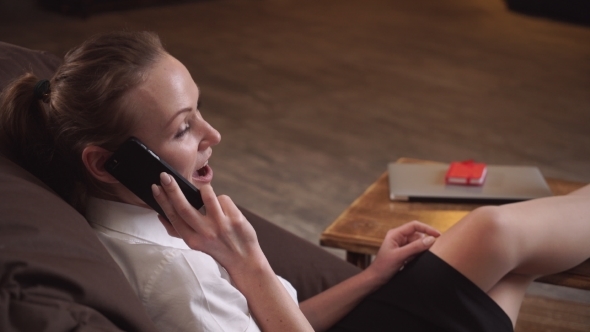 Woman Sit In a Chair  Speaking By Phone