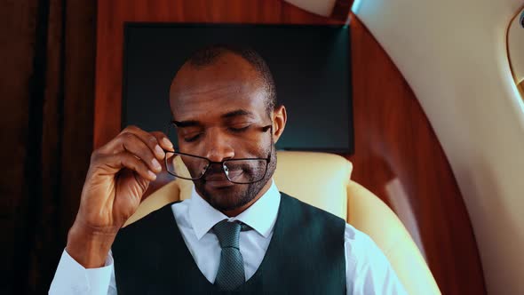 Stressed businessman removing eyeglasses, looking tired