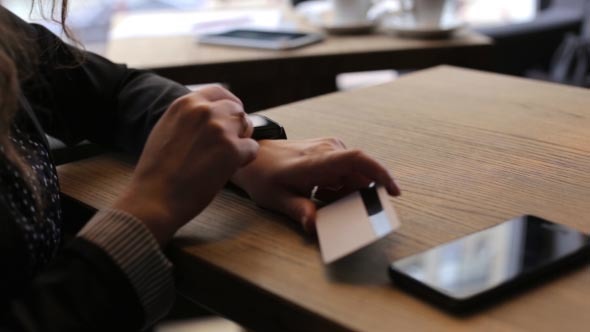 Business Woman Using Smart Watch and a Credit Card